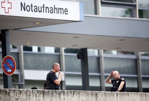 Police stand outside the university clinic in Steglitz, a southwestern district of Berlin, July 26, 2016 after a doctor had been shot at and the gunman had killed himself. REUTERS/Hannibal Hanschke